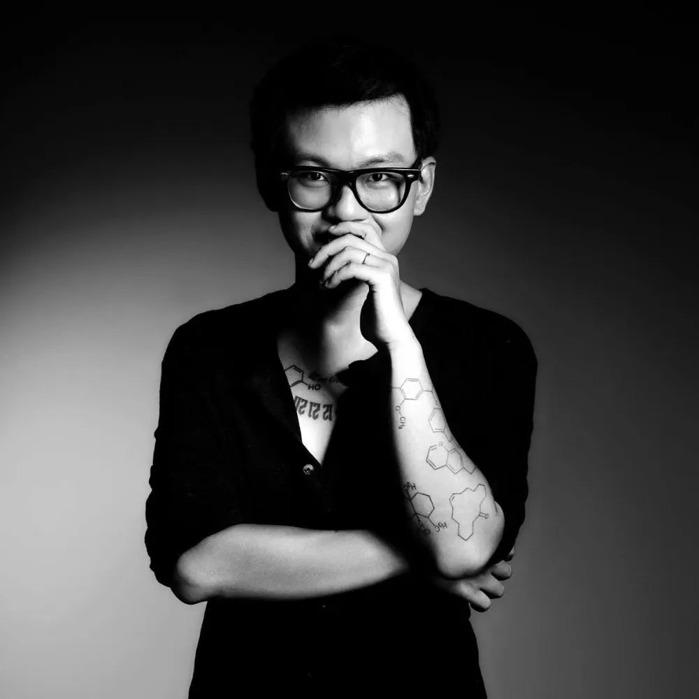 Person with glasses and visible chemistry tattoos, artistic black and white portrait