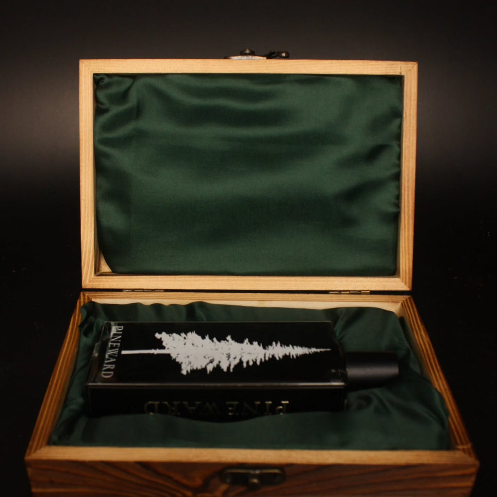 Pineward 100ml bottle lying in the open wooden coffret on green satin